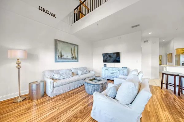 a living room with furniture a flat screen tv and a table