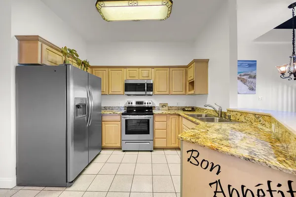 a kitchen with stainless steel appliances granite countertop a refrigerator and a stove top oven