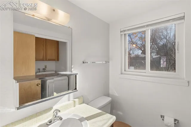 a bathroom with a sink toilet and mirror