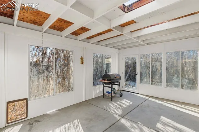 a view of workspace with furniture and large windows