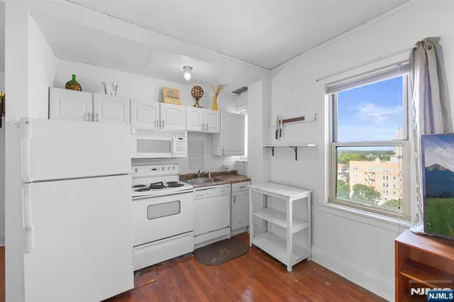 a kitchen with white cabinets and white appliances