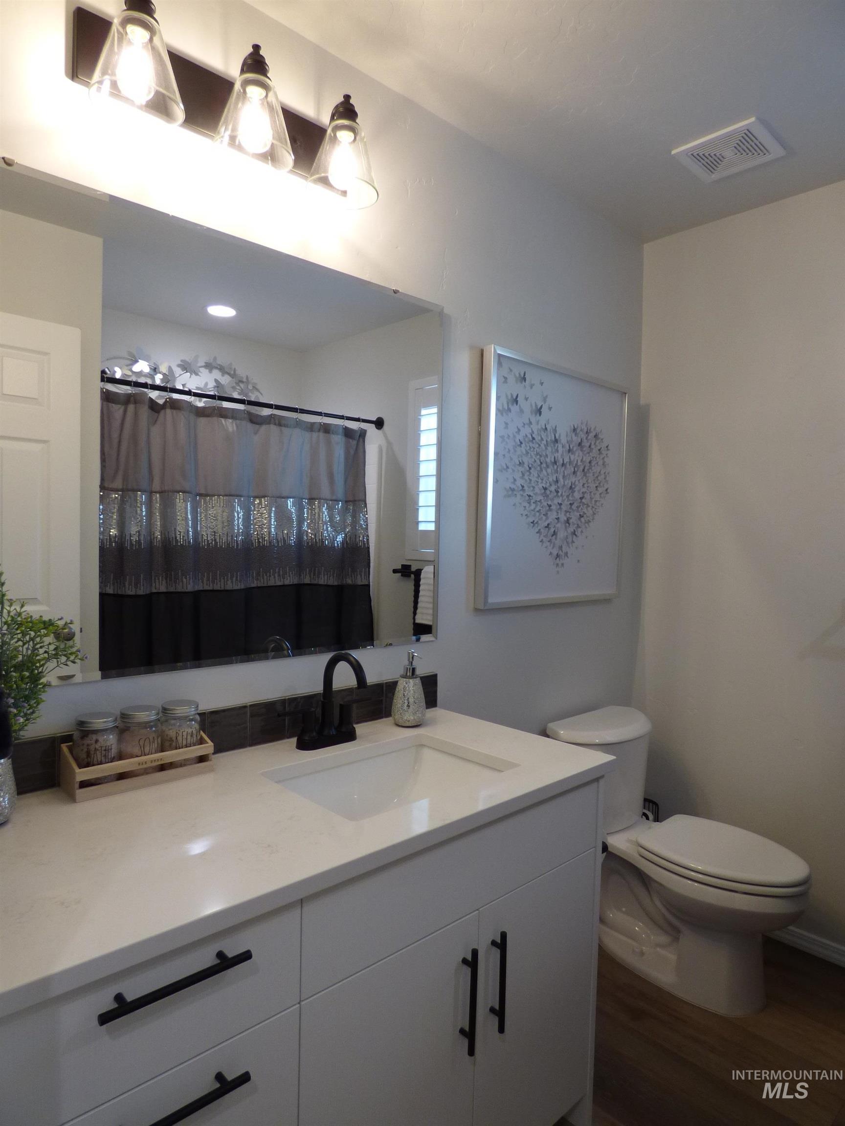 2708 East Buckaroo Drive Kuna, ID 83634 - Photo 15 of 48 Contemporary bathroom featuring a white vanity with matte black hardware, an undermount sink, and a black faucet