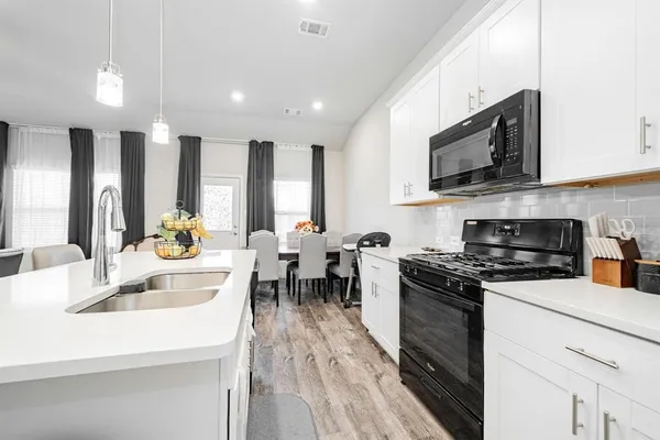 a kitchen with stainless steel appliances a stove sink microwave and cabinets