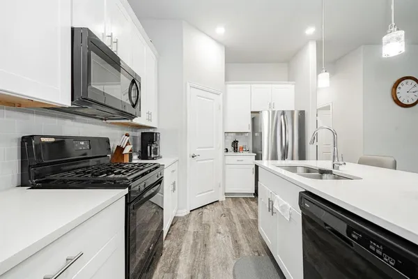 a kitchen with a sink stove top oven and refrigerator