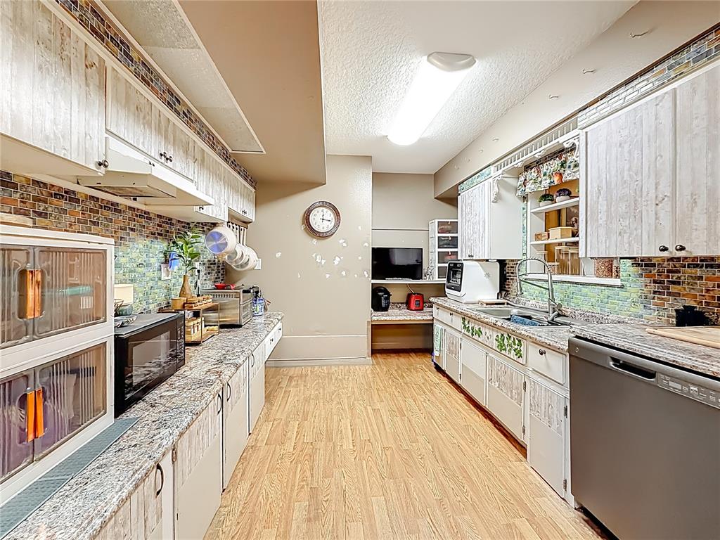 457 North Rooks Avenue Inverness, FL 34453 - Photo 18 of 61 a large kitchen with stainless steel appliances granite countertop lots of counter top space and wooden floor