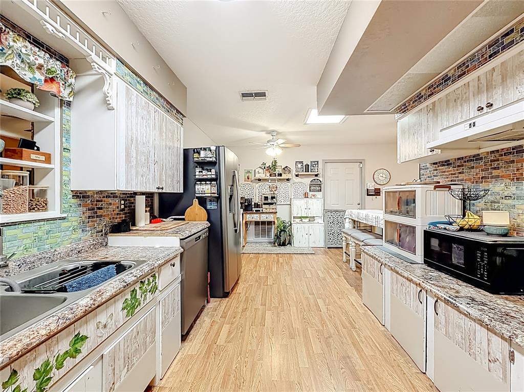 457 North Rooks Avenue Inverness, FL 34453 - Photo 20 of 61 a large kitchen with stainless steel appliances granite countertop a lot of counter space and wooden floors