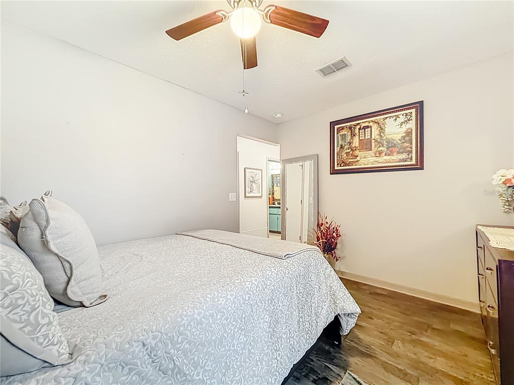 457 North Rooks Avenue Inverness, FL 34453 - Photo 34 of 61 a bedroom with a bed and a painting on the wall