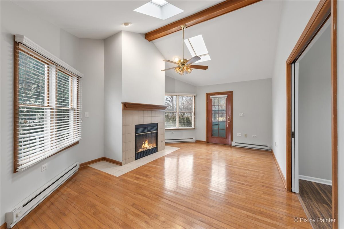 1095 Devonshire Avenue Naperville, IL 60540 - Photo 22 of 48 a view of an empty room with wooden floor fireplace and a window