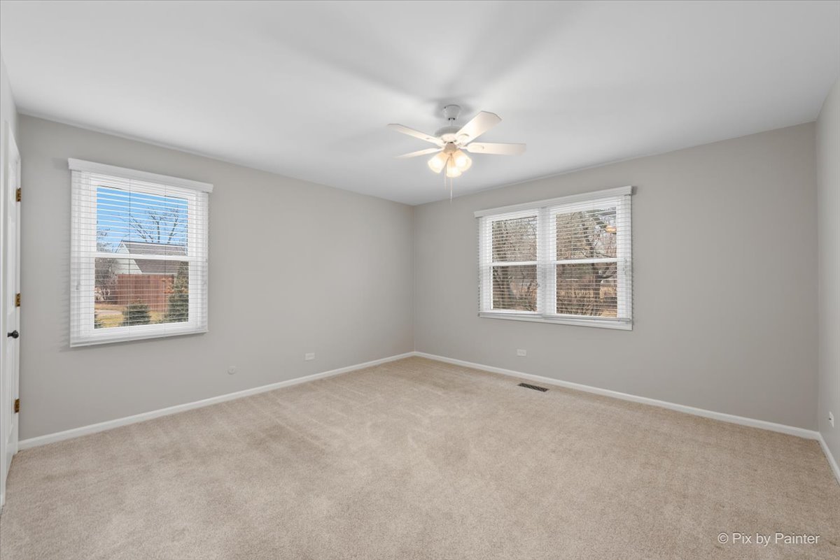 1095 Devonshire Avenue Naperville, IL 60540 - Photo 29 of 48 an empty room with a window and a ceiling fan