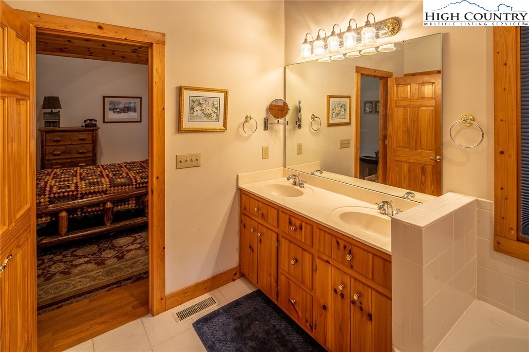 1278 Meadow Road Ferguson, NC 28624 - Photo 16 of 38 a bathroom with a double vanity sink mirror and shower