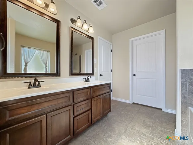 a bathroom with a double vanity sink and mirror