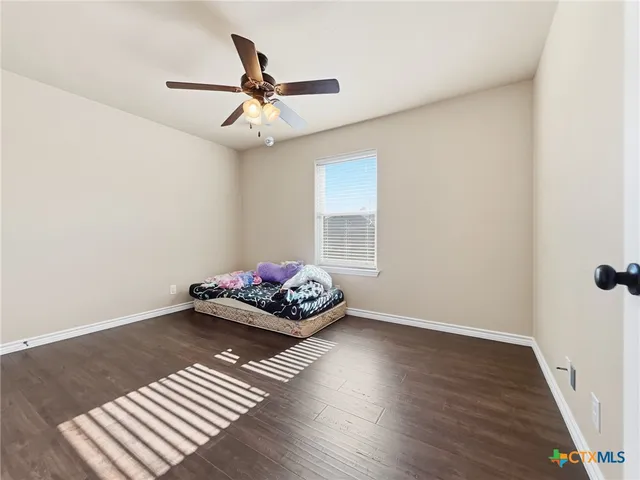 a living room with hard wood floor and a ceiling fan