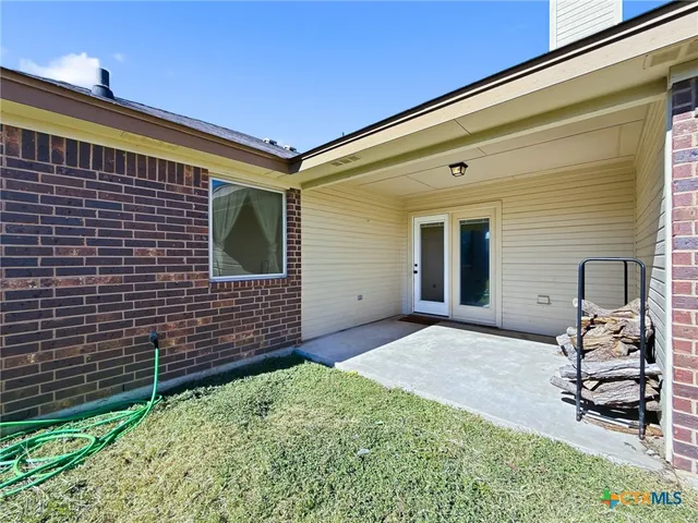 a view of backyard with a chair and potted plant