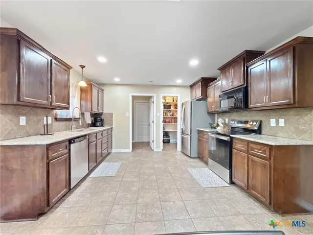 a large kitchen with stainless steel appliances lots of counter top space