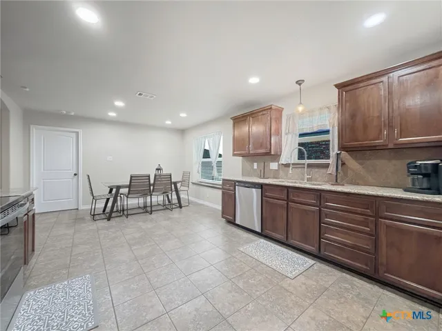 a kitchen with stainless steel appliances lots of counter top space cabinets and a sink