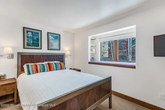 a bed sitting in a bedroom next to a window