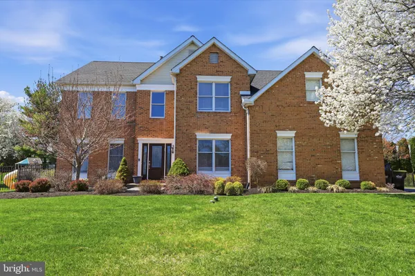 a front view of a house with a yard and trees