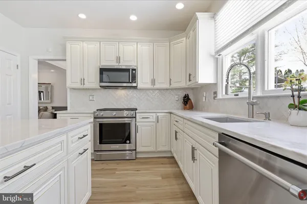 a kitchen with center island wooden floor furniture and a large window