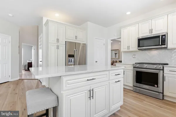 a kitchen with white cabinets and stainless steel appliances