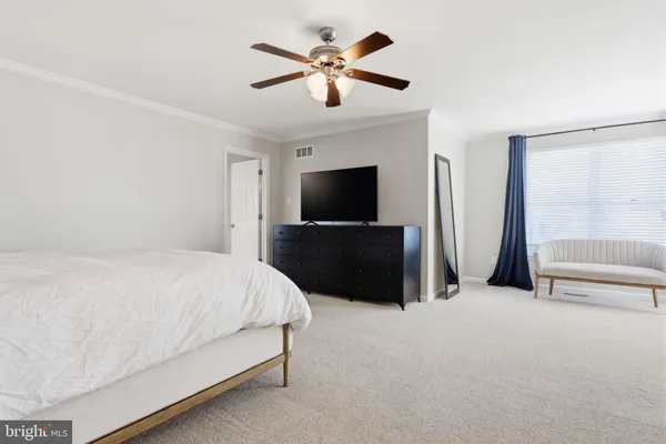 a bedroom with a bed and a ceiling fan