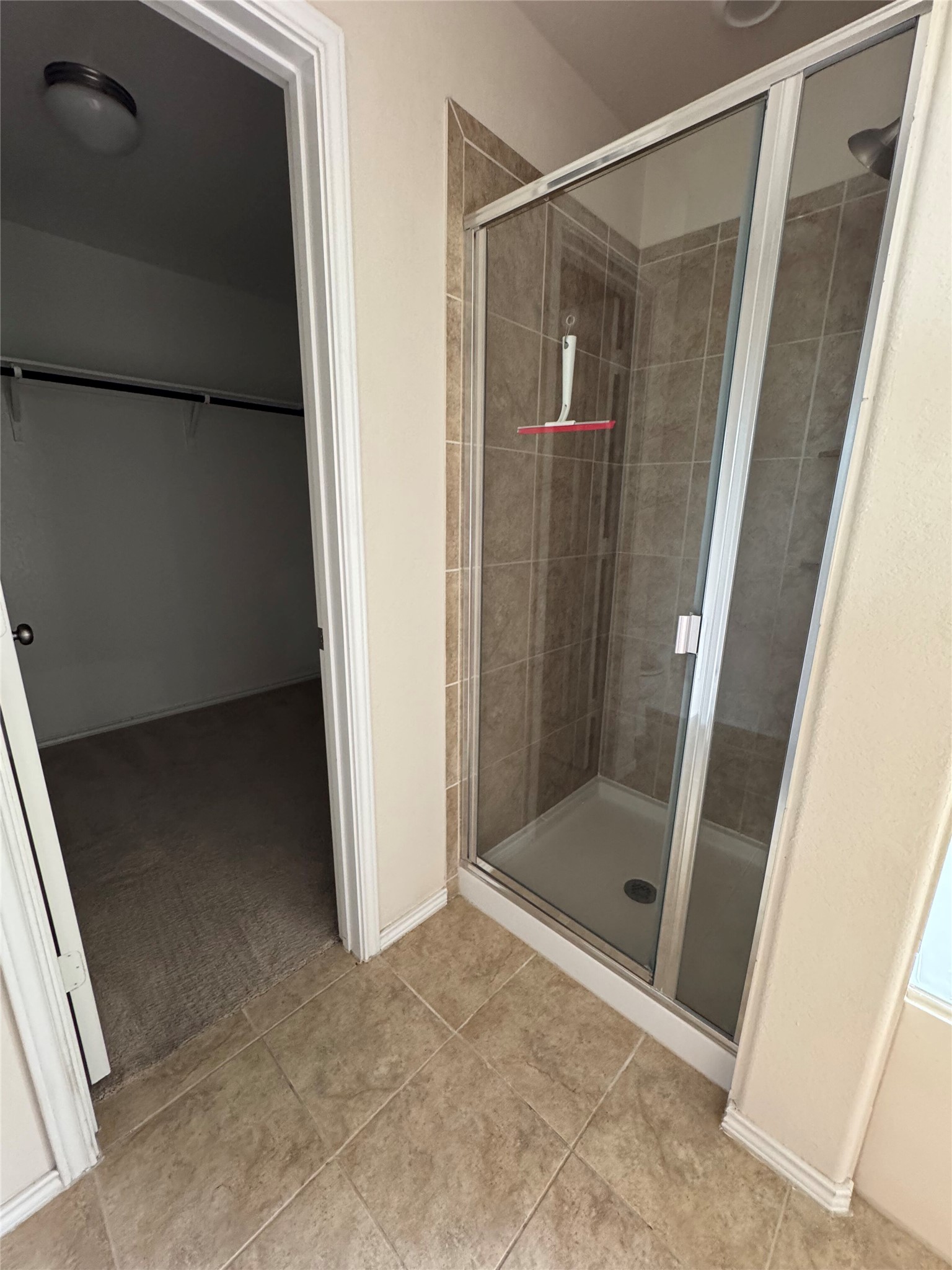 1108 Jackson Lane, Unit 5B Jarrell, TX 76537 - Photo 13 of 29 Bathroom featuring a spacious closet, a stall shower, and light tile patterned flooring