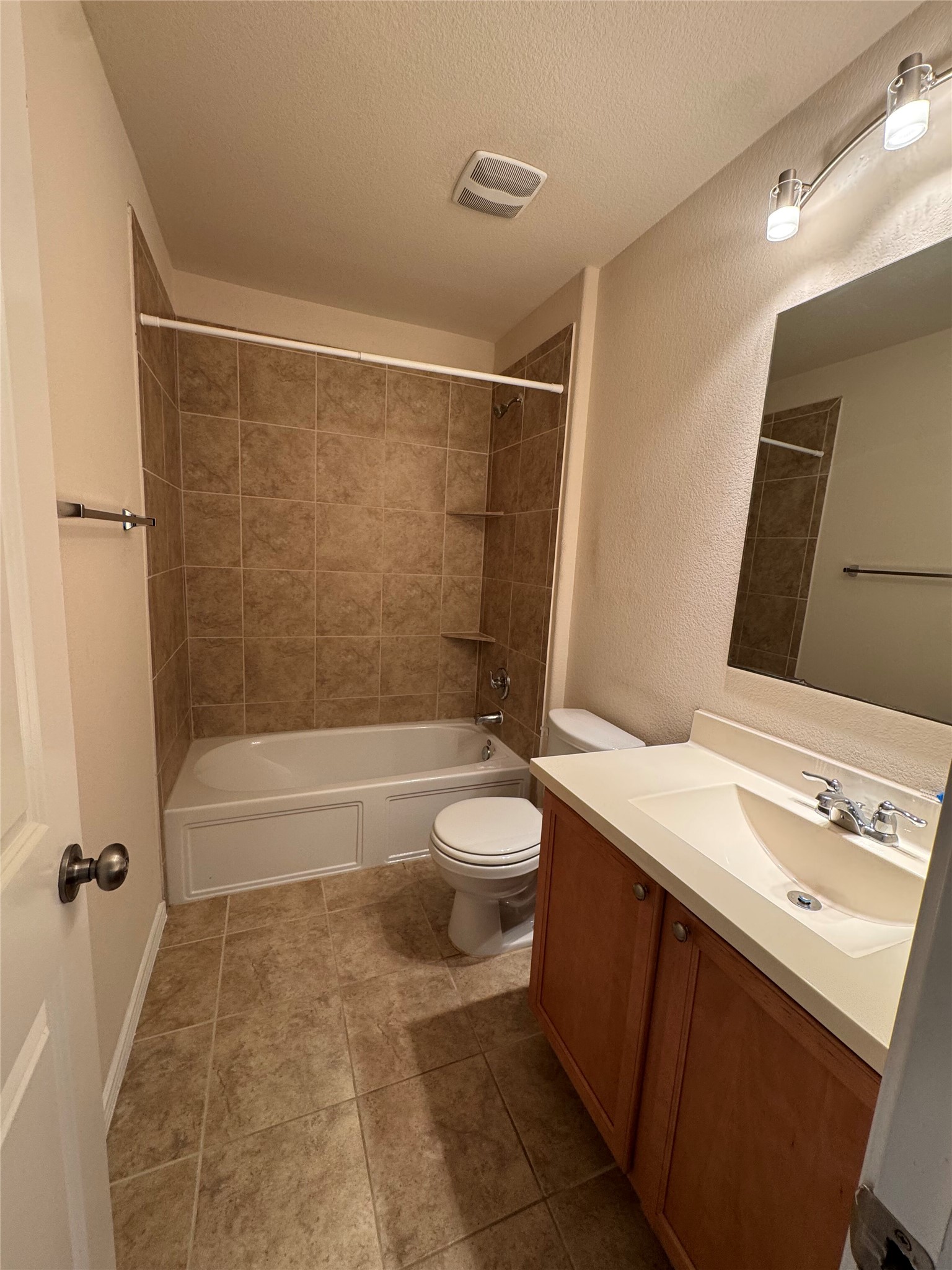 1108 Jackson Lane, Unit 5B Jarrell, TX 76537 - Photo 15 of 29 Bathroom featuring vanity, a textured wall, a textured ceiling, shower / bath combination, and light tile patterned floors
