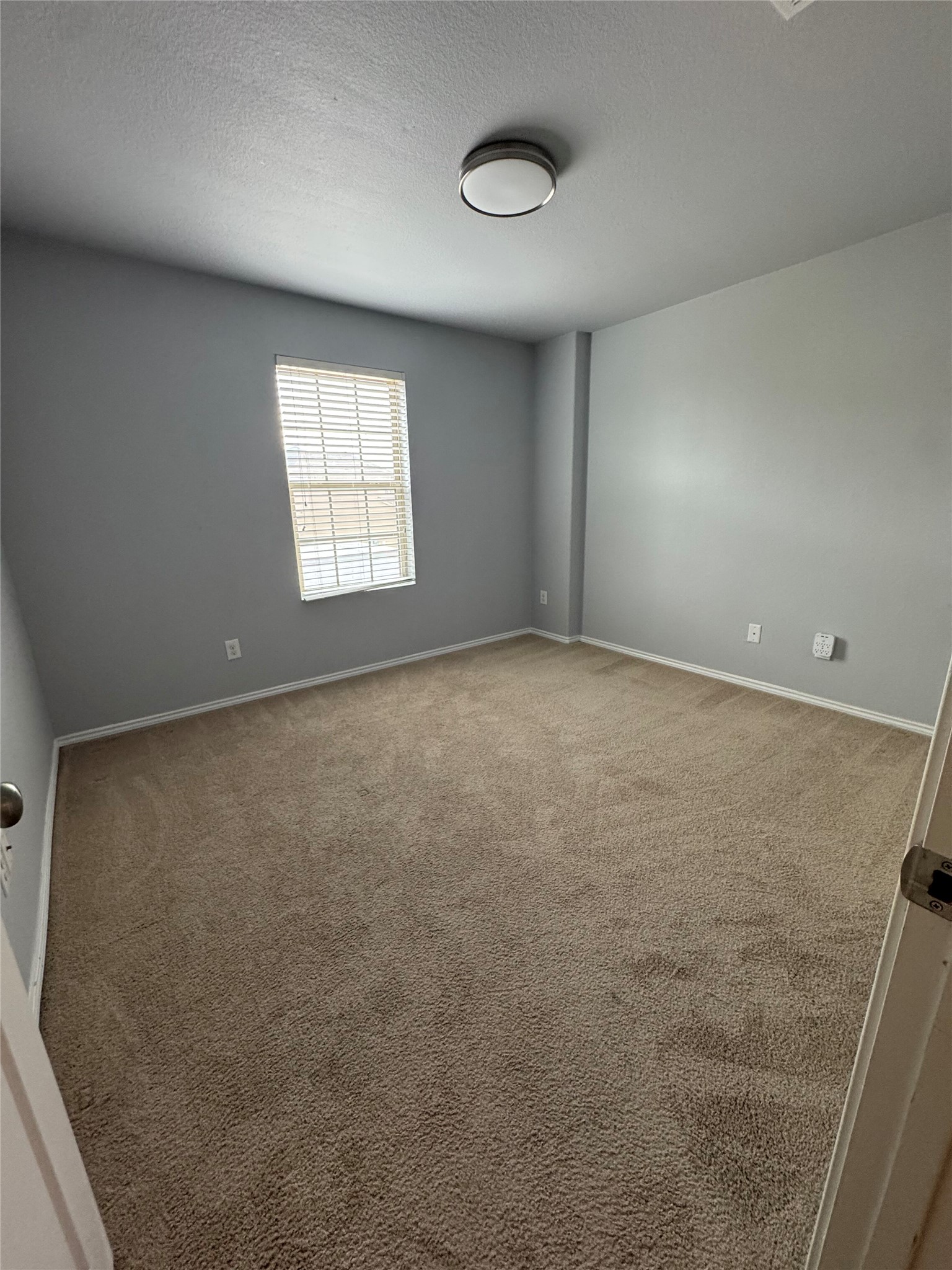 1108 Jackson Lane, Unit 5B Jarrell, TX 76537 - Photo 18 of 29 Spare room featuring light carpet and a textured ceiling