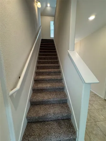 a view of an empty room with kitchen appliances and a ceiling fan