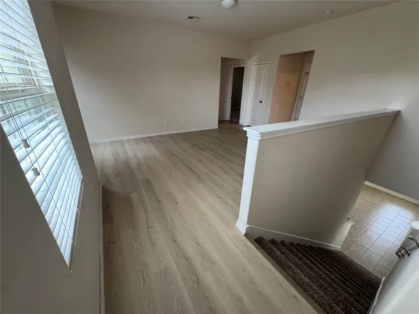 a view of an empty room with wooden floor