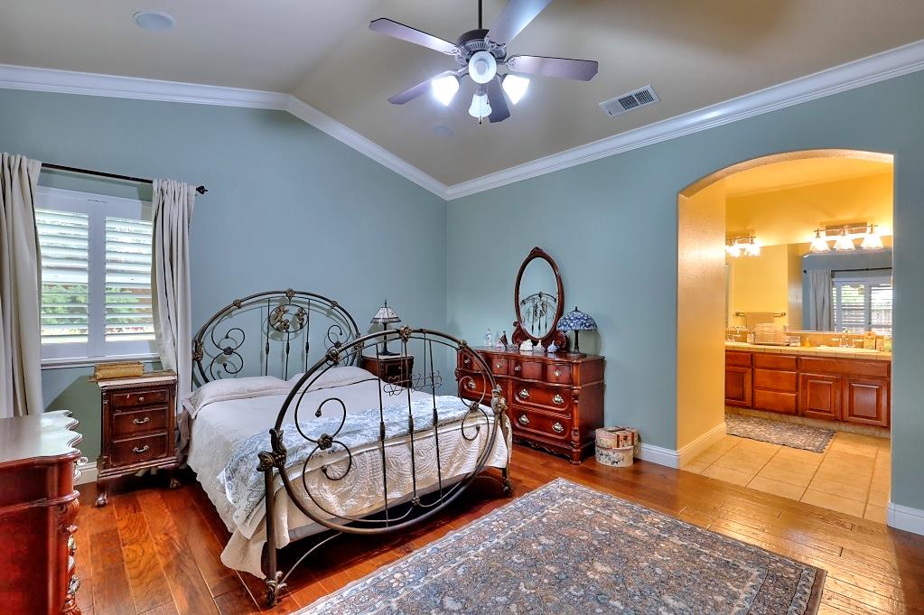 4152 Post Oak Drive Turlock, CA 95382 - Photo 53 of 71 a bedroom with a bed a chandelier and dresser