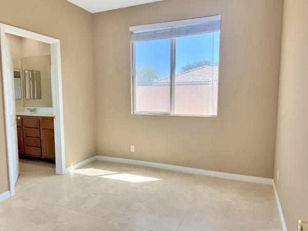 an empty room with a window and a dresser