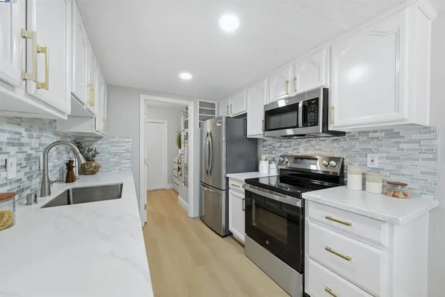 a kitchen with stainless steel appliances a stove sink microwave and cabinets
