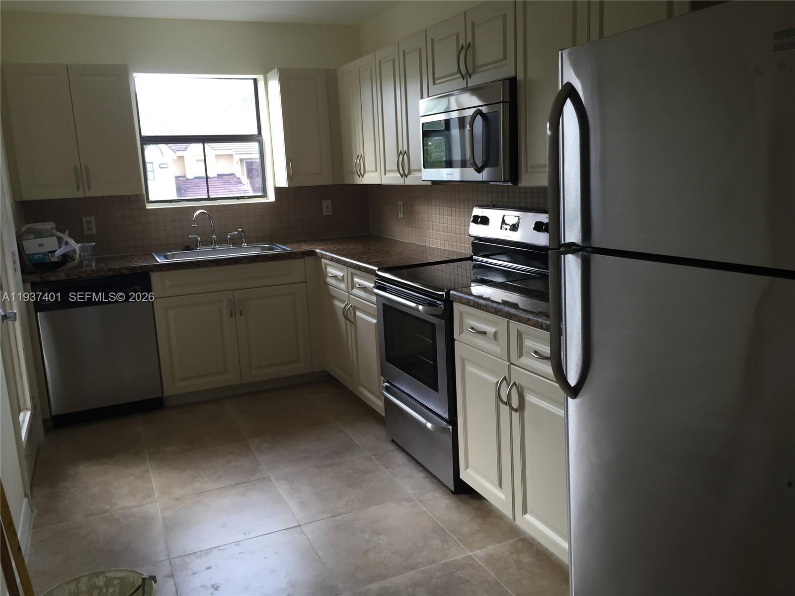 10441 Southwest 156th Court, Unit 421 Miami, FL 33196 - Photo 17 of 36 a kitchen with stainless steel appliances granite countertop a sink stove and refrigerator
