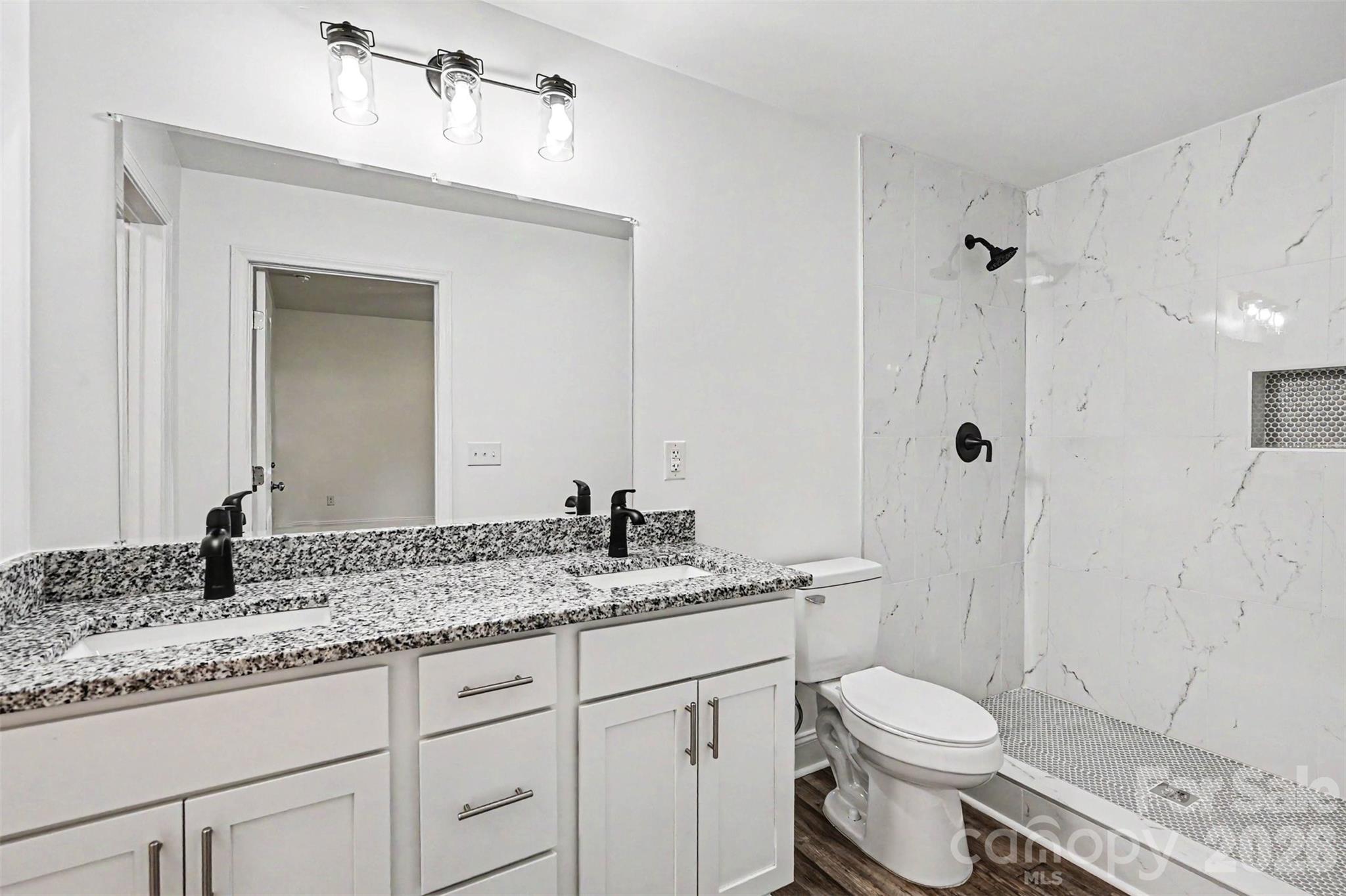 405 Aquadale Road Albemarle, NC 28001 - Photo 24 of 29 a bathroom with a granite countertop sink a toilet and a mirror