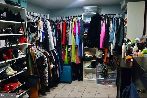 a view of walk in closet with clothes and shoes
