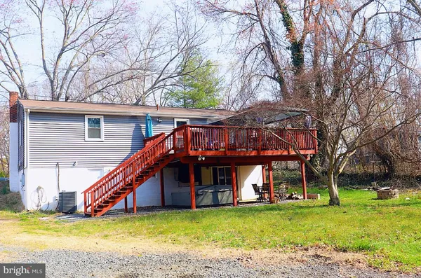 a view of a house with a small yard and deck