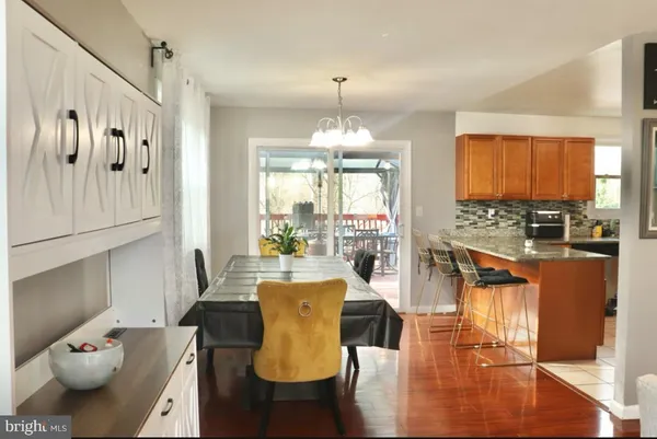 a view of a dining room with furniture a chandelier and wooden floor