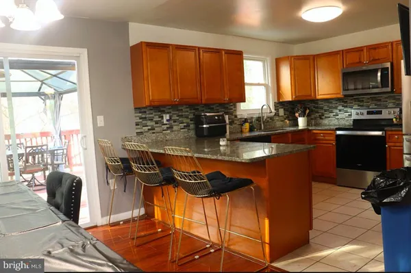 a kitchen with granite countertop a stove a sink and a microwave