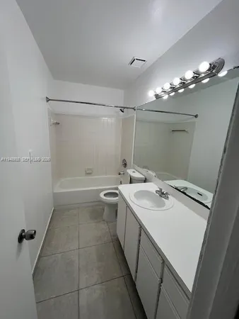 a bathroom with a sink a toilet a mirror and shower