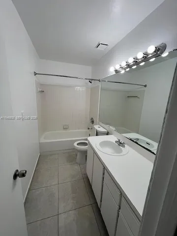 a bathroom with a sink a toilet a mirror and shower