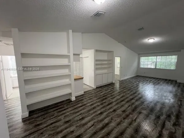 a view of wooden floor and windows in a room