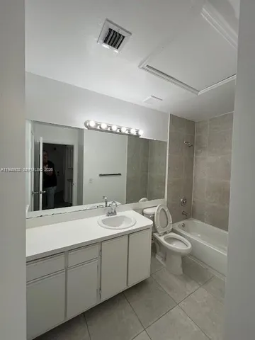 a bathroom with a double vanity sink toilet mirror and bathtub