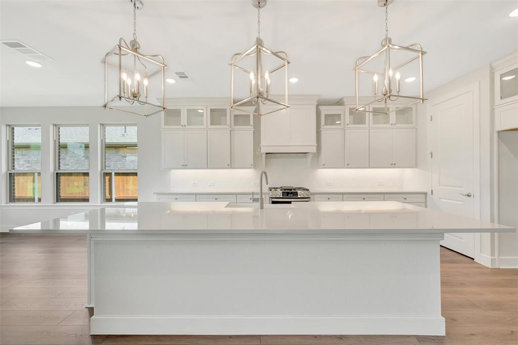 11460 Wulstone Road Fort Worth, TX 76052 - Photo 9 of 40 a room with a chandelier fan and wooden floor