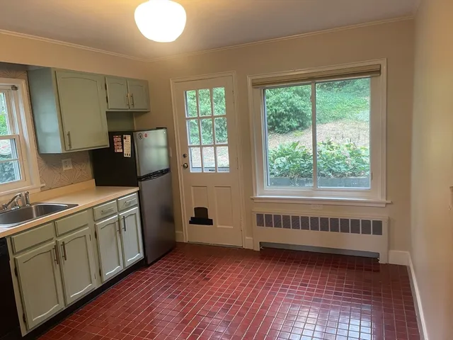 a kitchen with a sink and wooden floor