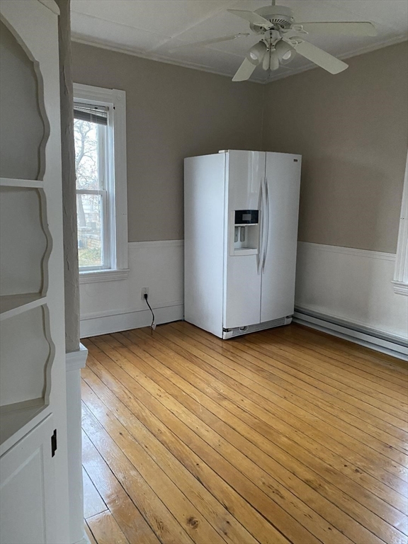 147 Stetson Street, Unit 2 Fall River, MA 02720 - Photo 5 of 8 an empty room with wooden floor cabinet and windows