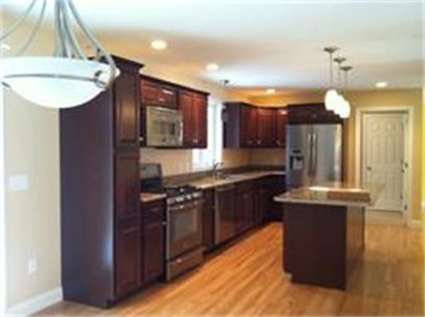 33 Beechnut Road Dracut, MA 01826 - Photo 10 of 30 a kitchen with kitchen island granite countertop wooden cabinets and a stainless steel appliances