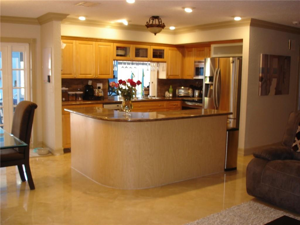 4225 Jackson Street Hollywood, FL 33021 - Photo 3 of 25 a view of a kitchen with kitchen island stainless steel appliances a refrigerator a stove a sink a dining table and chair