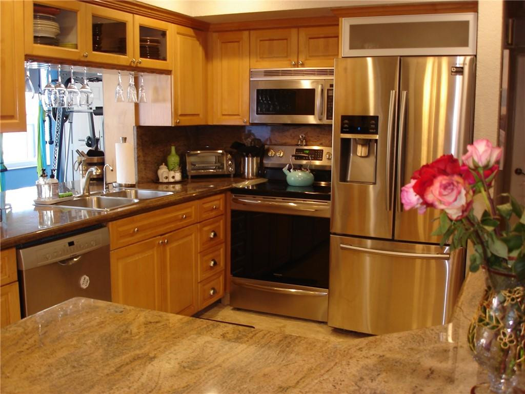 4225 Jackson Street Hollywood, FL 33021 - Photo 4 of 25 a kitchen with stainless steel appliances granite countertop a refrigerator stove top oven and sink