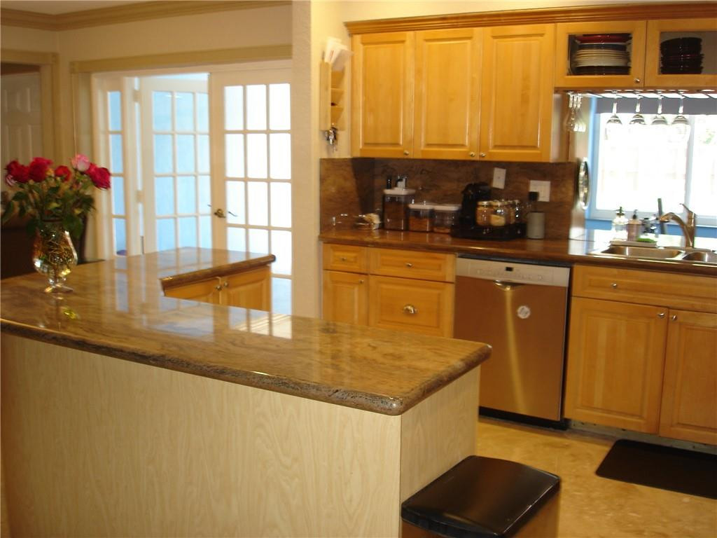 4225 Jackson Street Hollywood, FL 33021 - Photo 5 of 25 a kitchen with stainless steel appliances granite countertop a sink a stove and a refrigerator with wooden floor