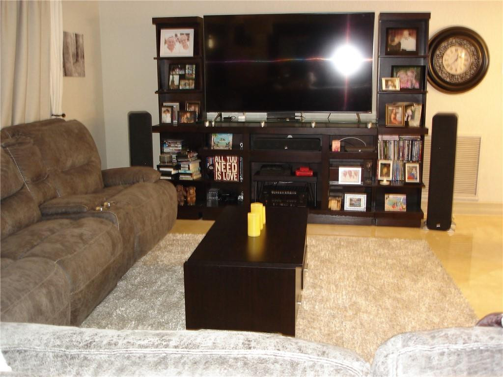 4225 Jackson Street Hollywood, FL 33021 - Photo 9 of 25 a living room with furniture a flat screen tv and a wall clock